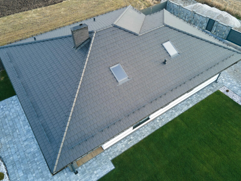Aerial view of private house with ceramic shingles covered roof top. Investment in real estate concept.